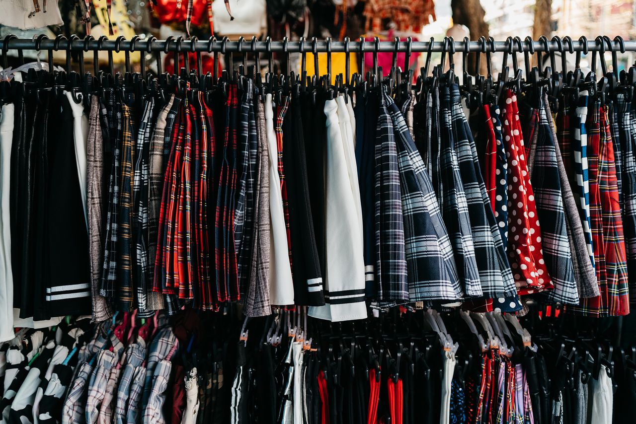 Vibrant selection of skirts and clothing hanging on a retail store rack.