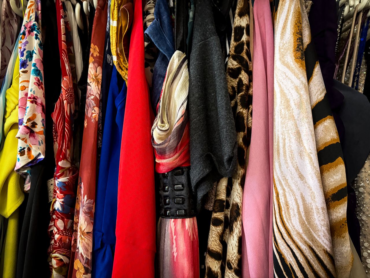 A vibrant collection of vintage clothes on hangers showcasing various patterns and fabrics.